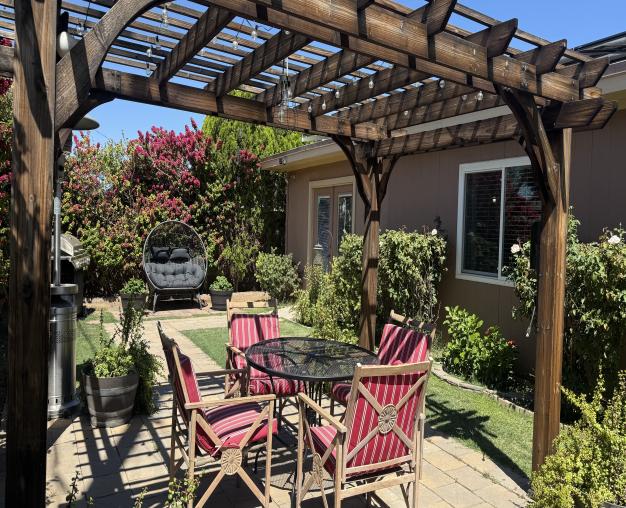 Garden table and chairs under a wooden pergola