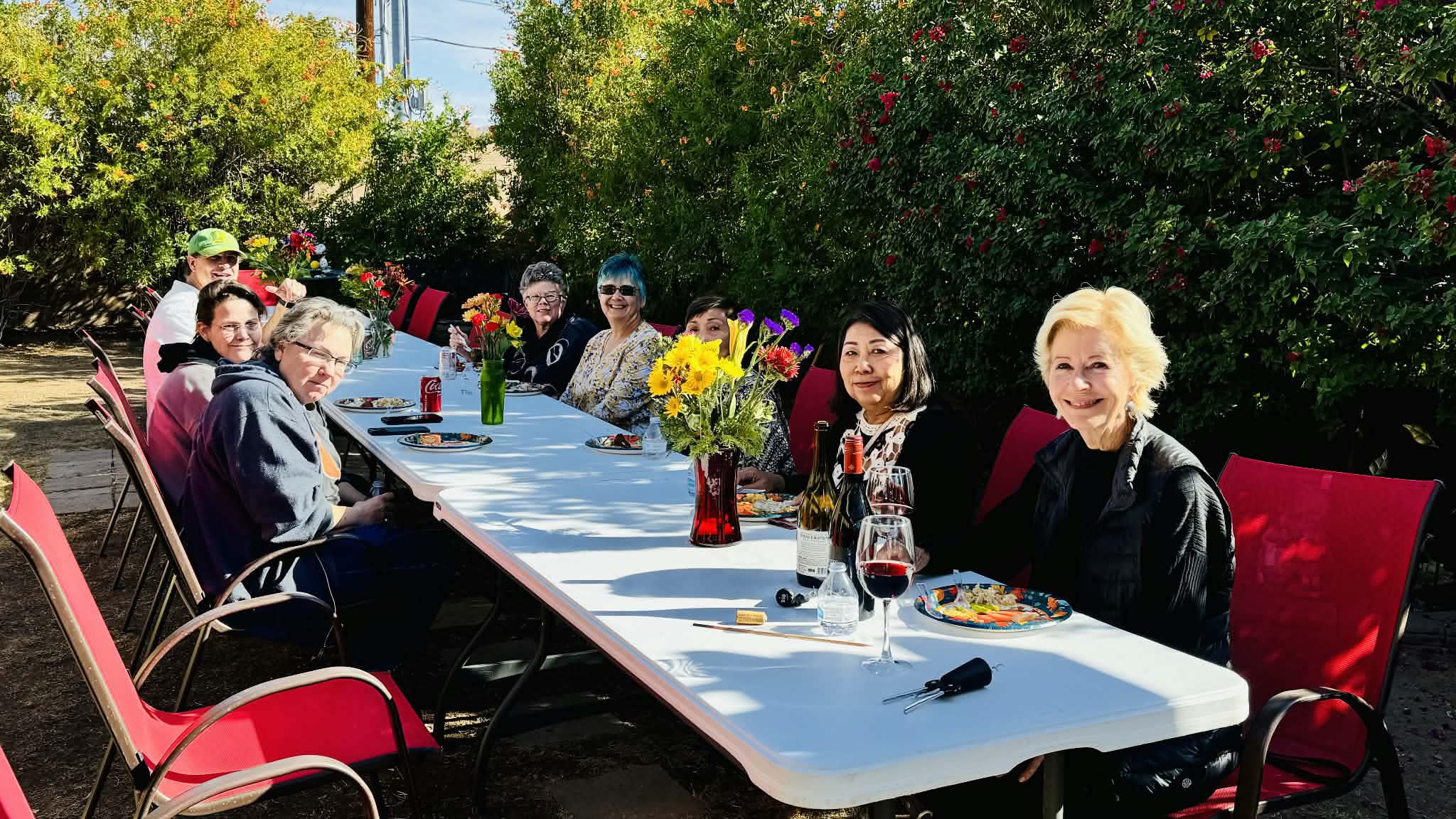 Residents, caregivers and guests enjoying a meal together outdoors