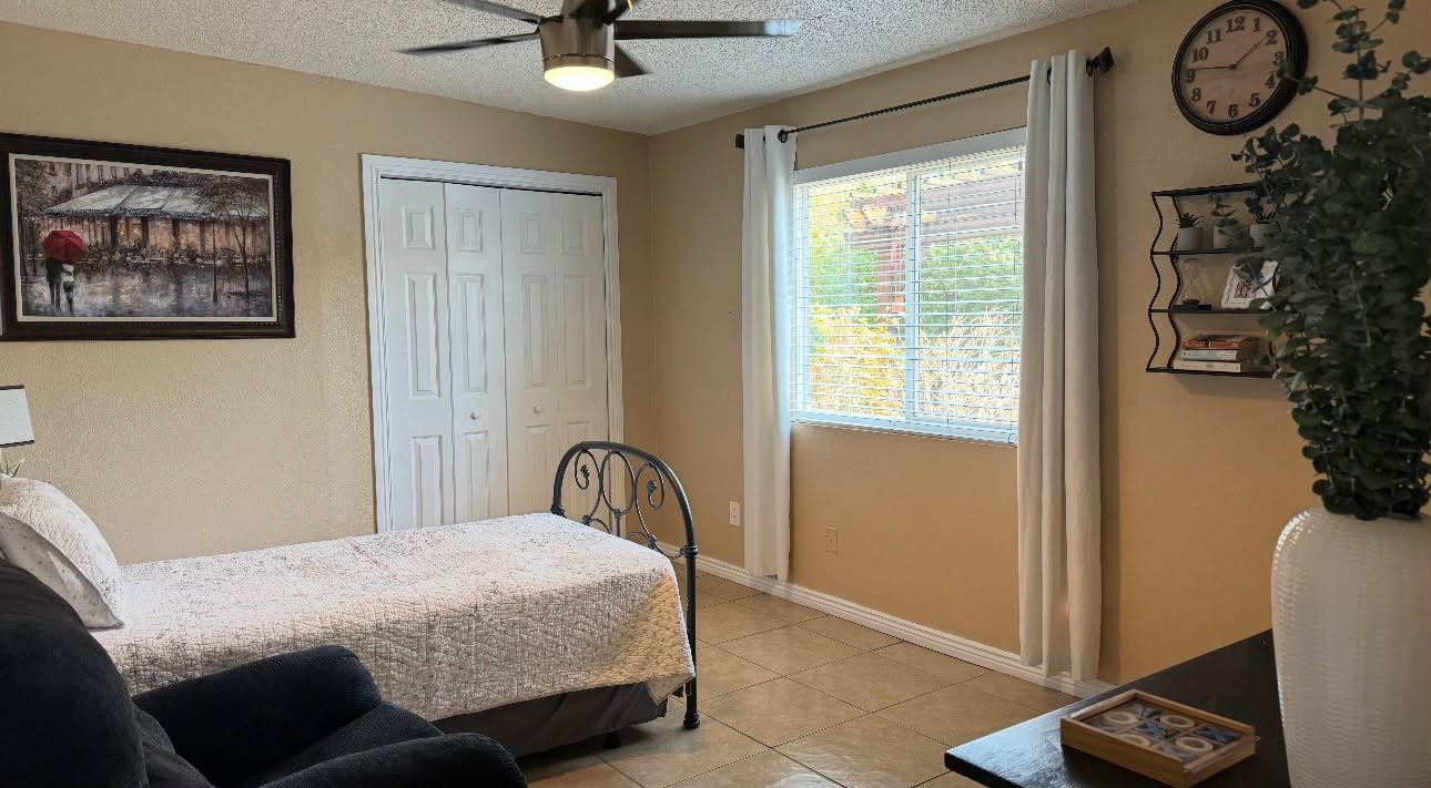 Bedroom with a window, closet, bed and sitting area
