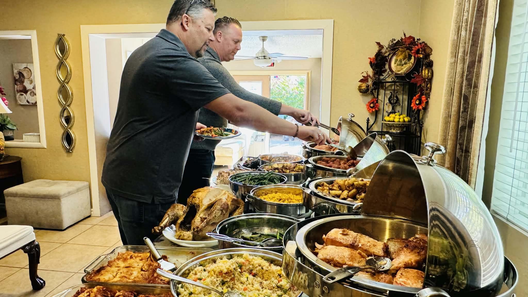 Guests serving themselves from a table of food at Rivendell